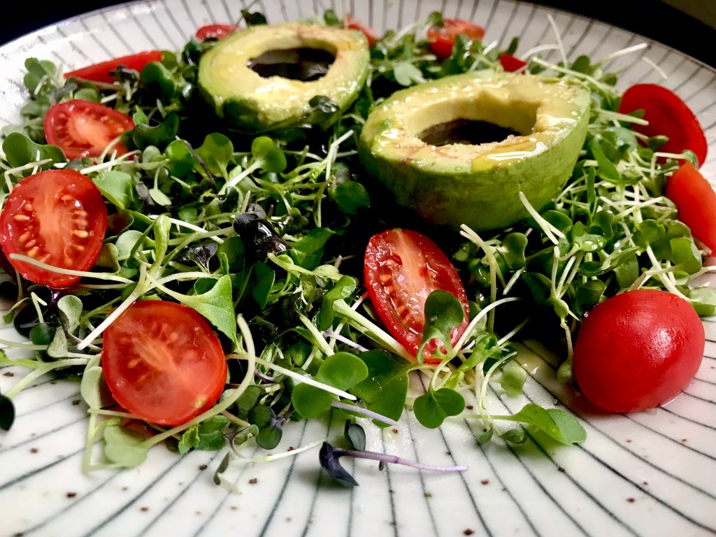 Pumpkin Seed Oil in Avocado on Micro-greens surrounded by&nbsp;Tomatoes